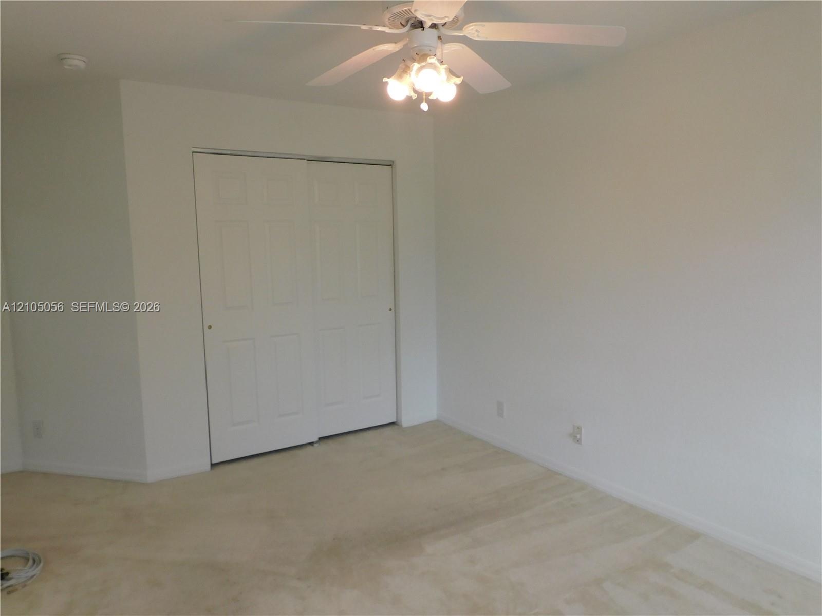 Garage space with an automatic garage door opener and two overhead fluorescent light fixtures