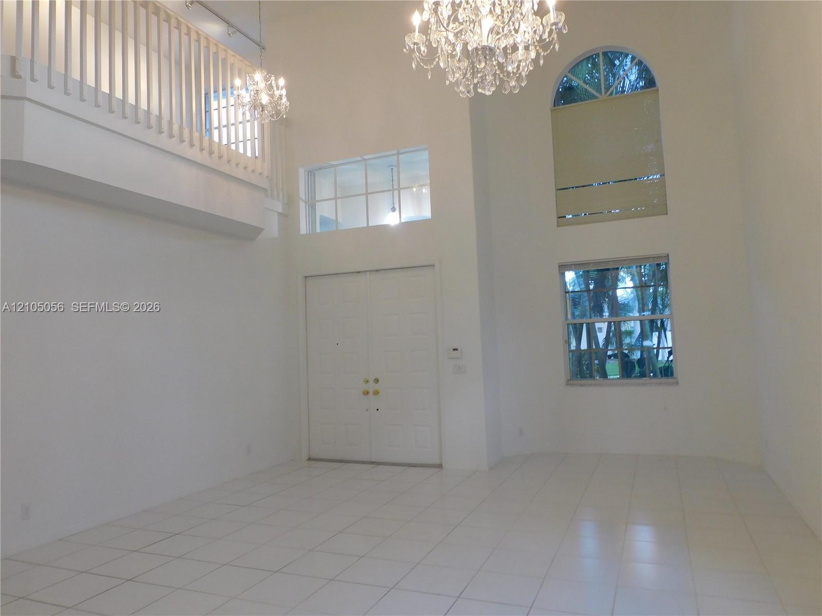 Double-door entry, tiled flooring in all social areas, soaring ceilings, arch-top window, and two crystal chandeliers