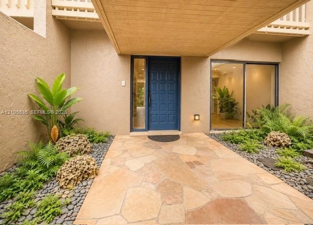 Flagstone walkway with river rock landscaping beds, featuring a deep blue entry door, and a dedicated entry light fixture