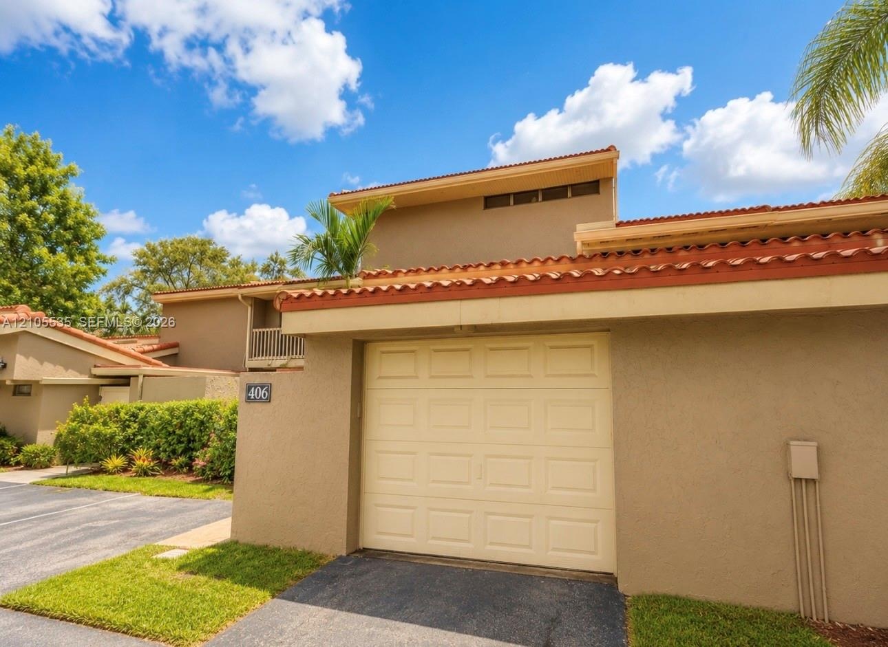 Stucco exterior with a tiled roof, integrated garage, and private balcony