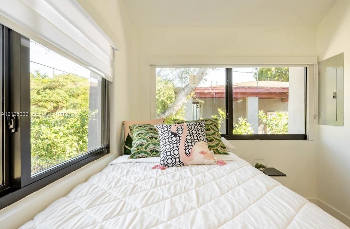 Dual windows with black frames and white window treatments