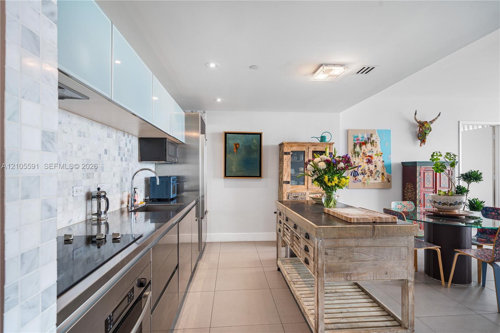 Sleek kitchen featuring a stainless steel appliance suite, mosaic tile backsplash, modern cabinetry, and recessed lighting