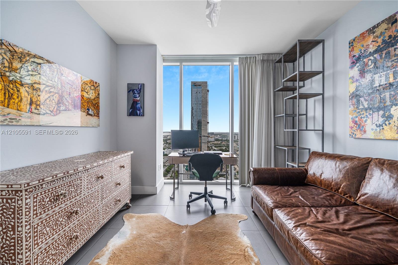 Floor-to-ceiling windows, light gray wall color, built-in shelving, and light wood-finish flooring