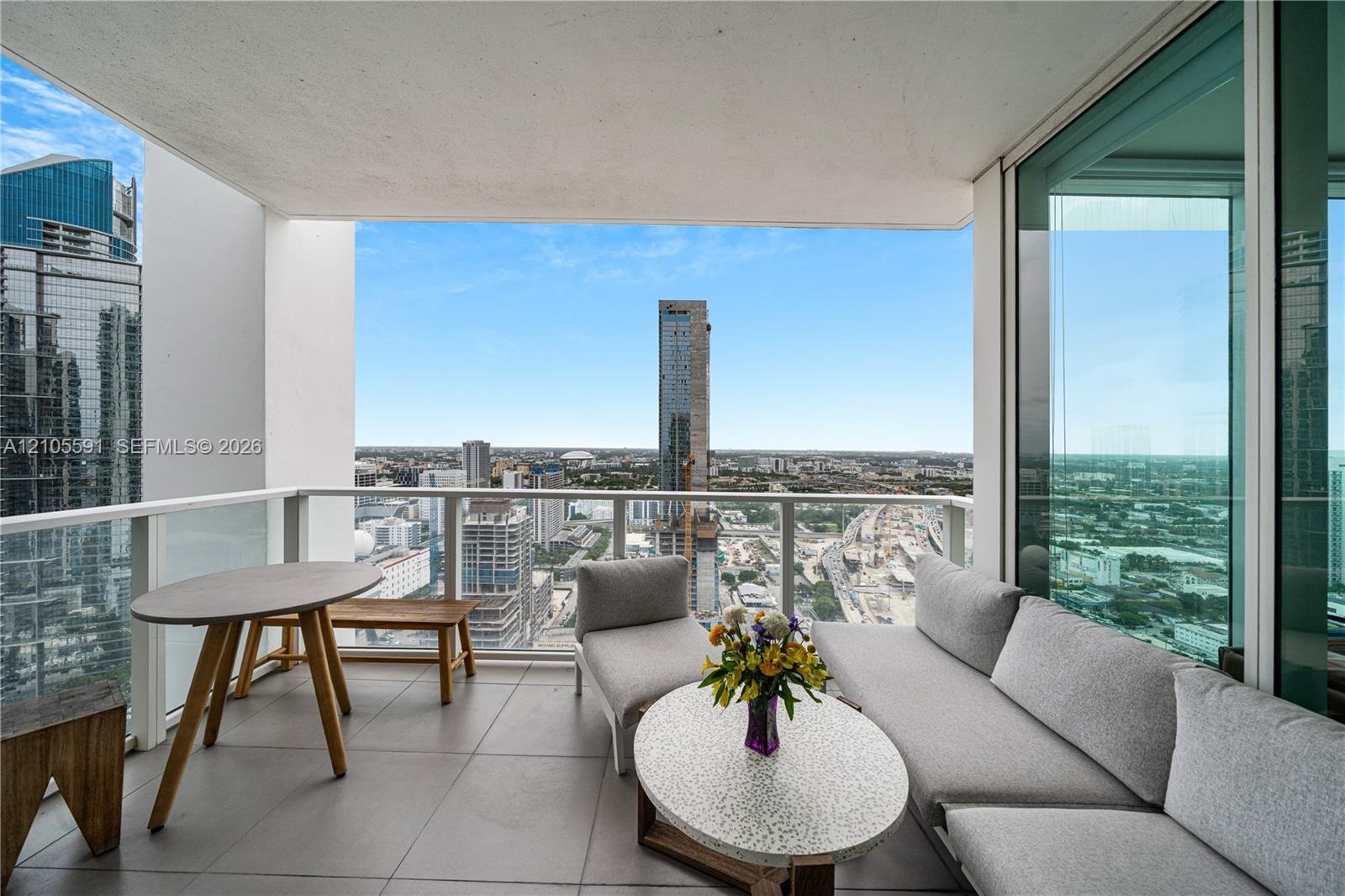 Balcony with tile flooring, glass railings, and expansive city scenery