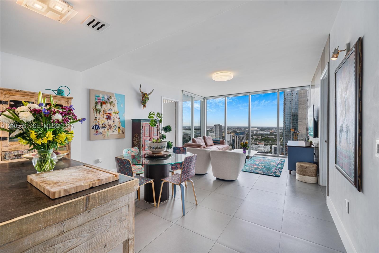 Expansive window wall with cityscape, sleek tile flooring, and integrated ceiling lighting