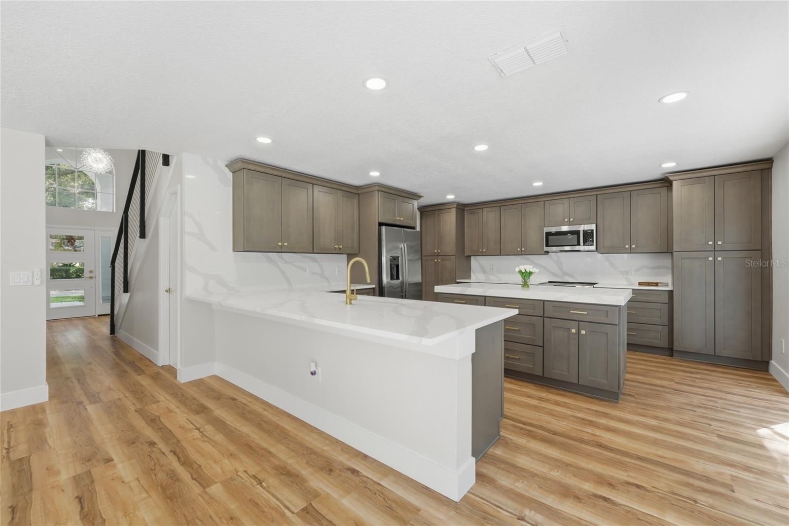 This chef’s dream kitchen offers elegant stone countertops, a deep undermount sink, and ample storage