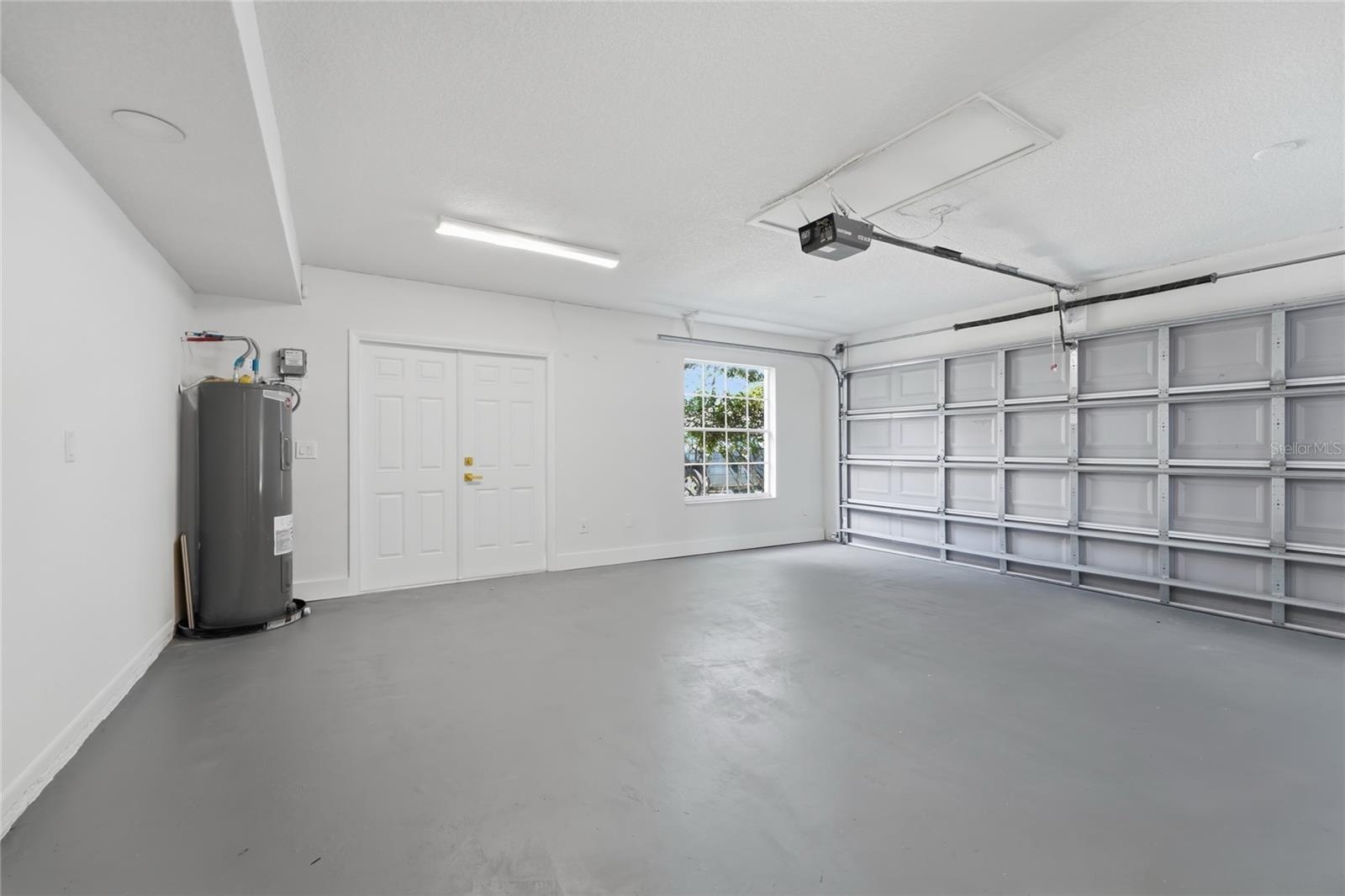 Spacious garage with generous parking space, windows for natural light, and a dedicated exit door