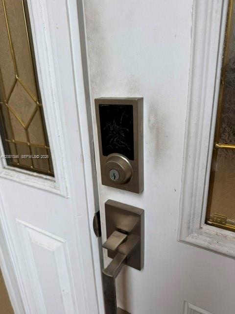 White paneled door with decorative glass inserts and brushed nickel hardware