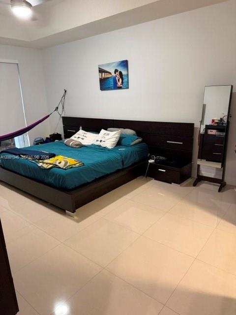 Recessed ceiling, ceiling fan, white walls, light-toned tile flooring, and a window with a roller shade