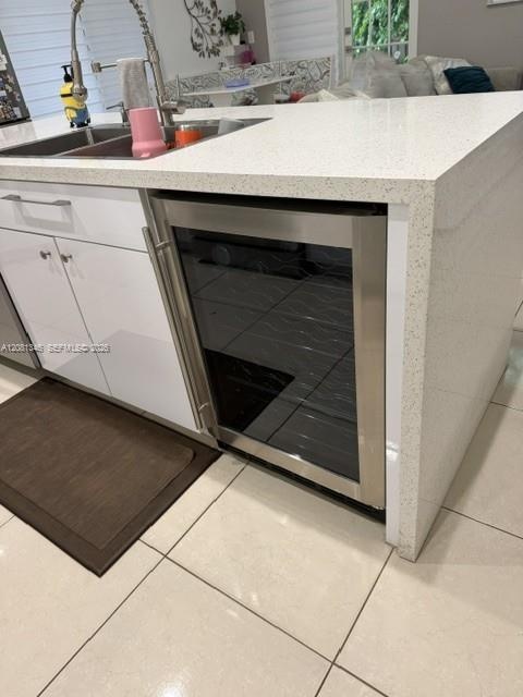 Waterfall-edge island with a built-in stainless steel beverage cooler, undermount sink, and pull-down faucet