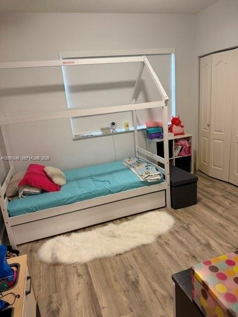 Wood-finish flooring with neutral wall paint and white bi-fold closet doors