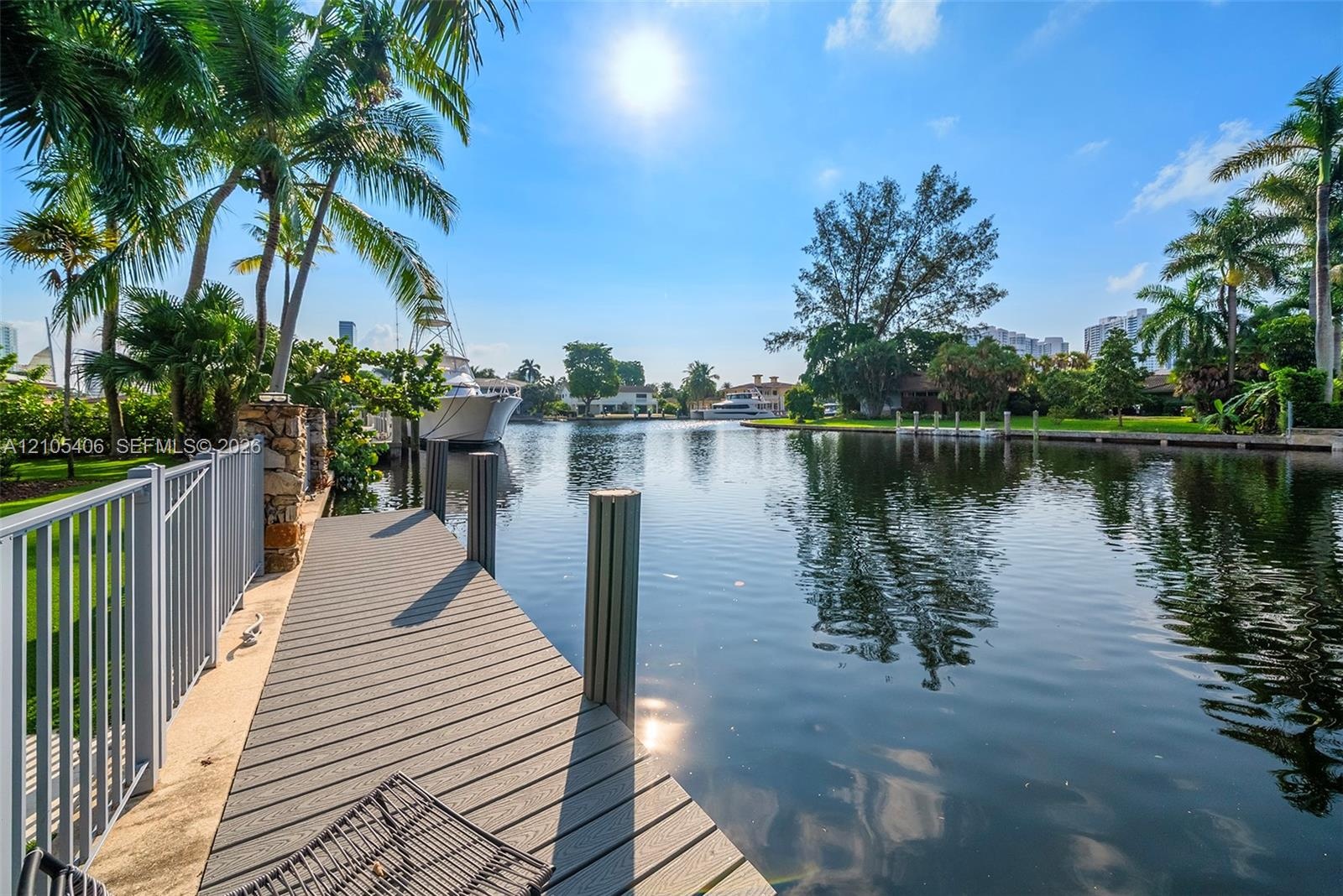 Waterfront property featuring a composite deck, aluminum railing, and tropical landscaping