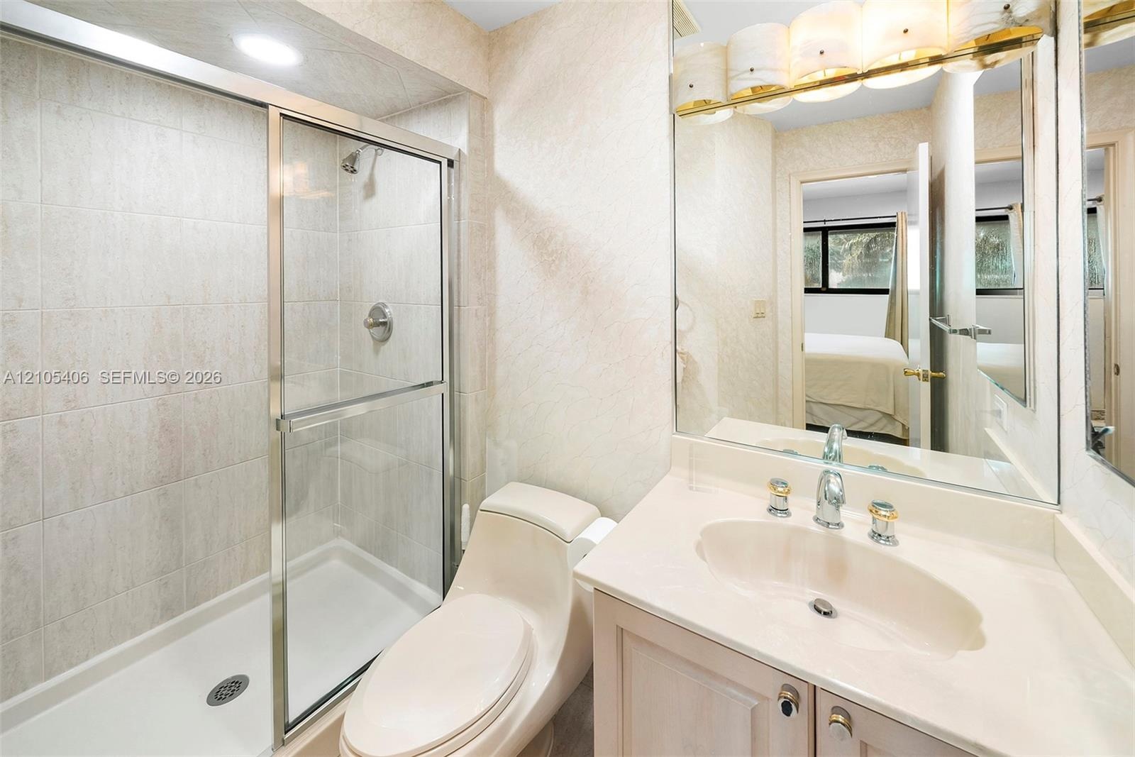 Vanity with an integrated sink, polished chrome faucet, and gold-toned light fixture