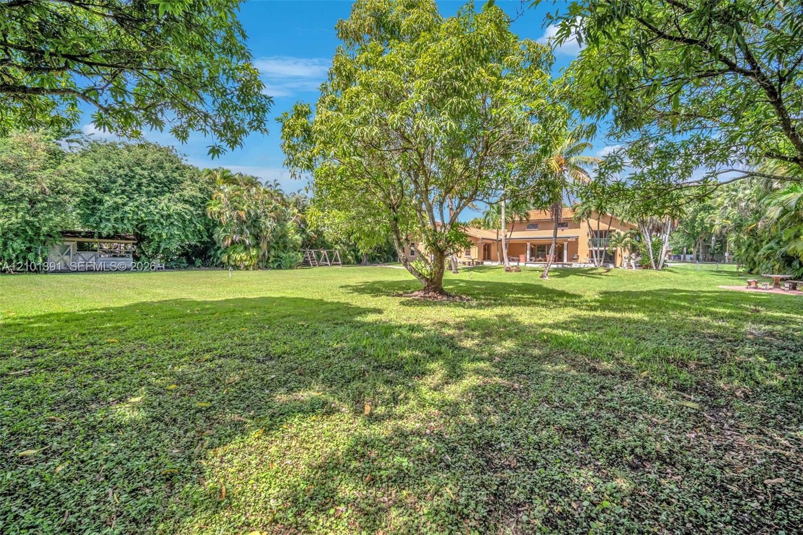 Expansive green space featuring a variety of mature trees and landscaping