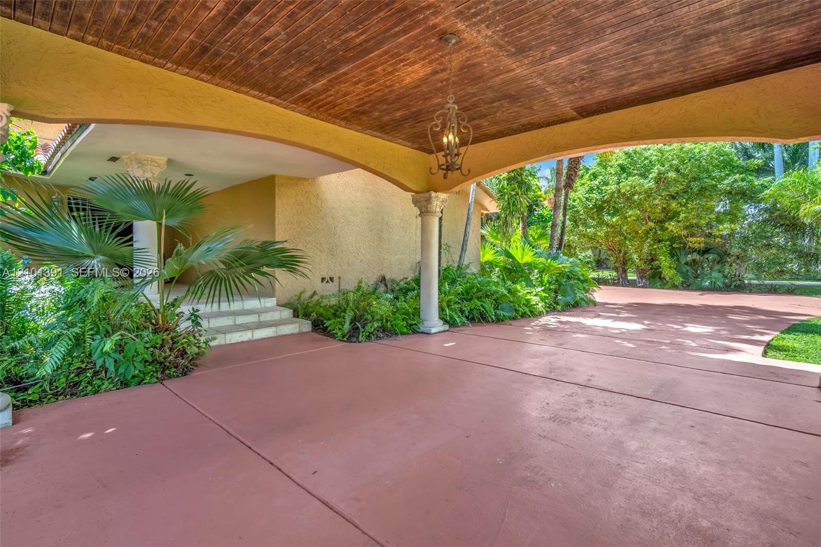 Covered entry with a wood-paneled ceiling and decorative chandelier