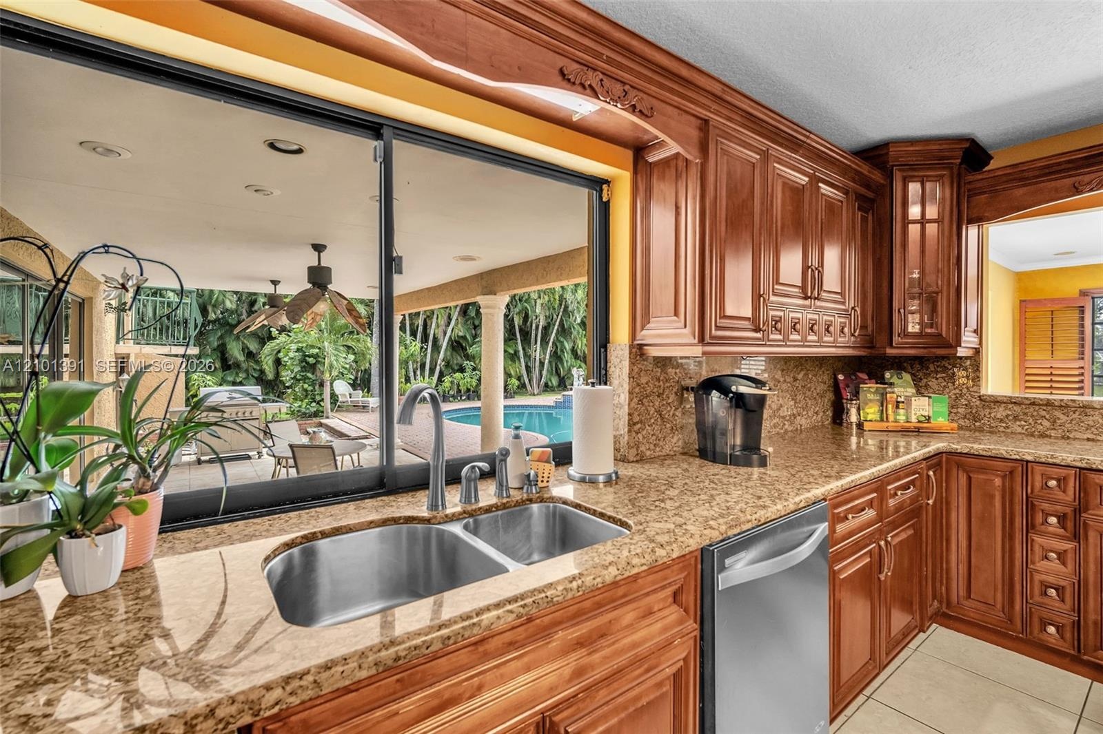 Kitchen featuring wooden cabinetry, granite countertops, stainless steel appliances, and a double basin sink