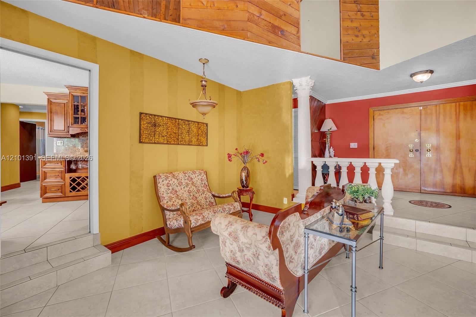 Tiled flooring, wood-paneled ceiling, decorative wall paneling, and an interior architectural column