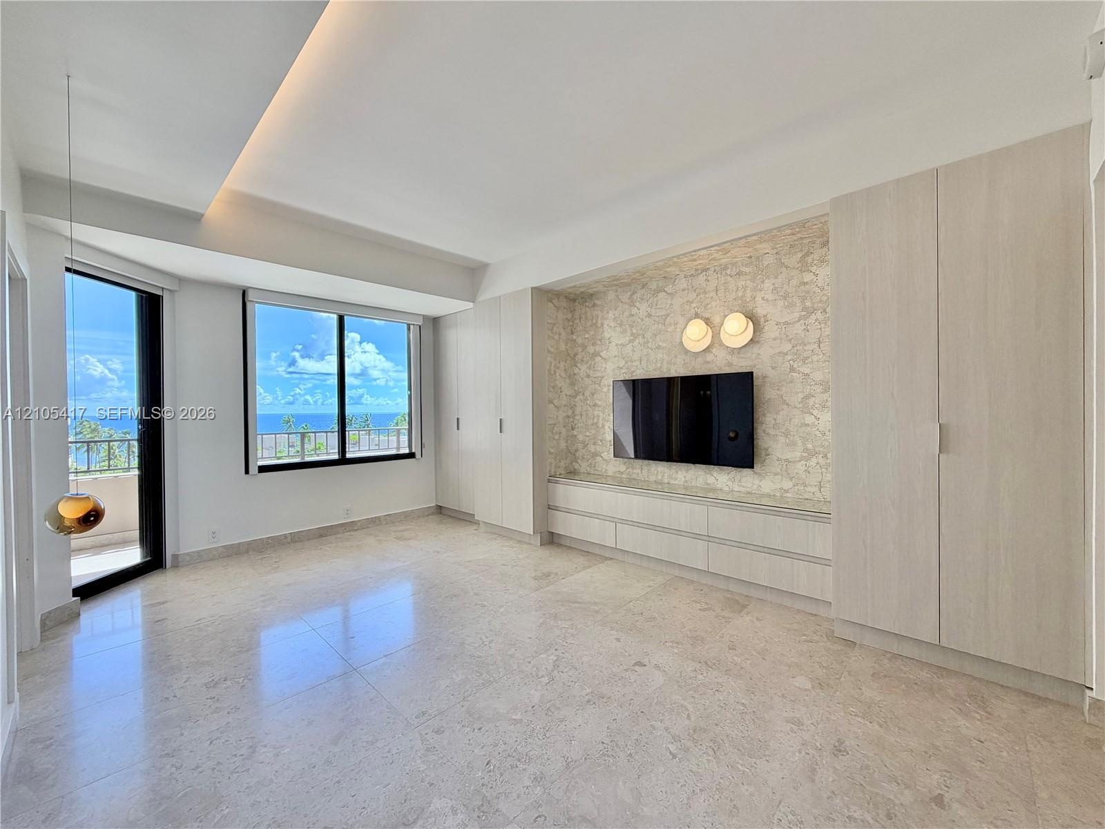 Integrated built-in cabinetry, recessed ceiling lighting, a wall-mounted media console, and a private balcony