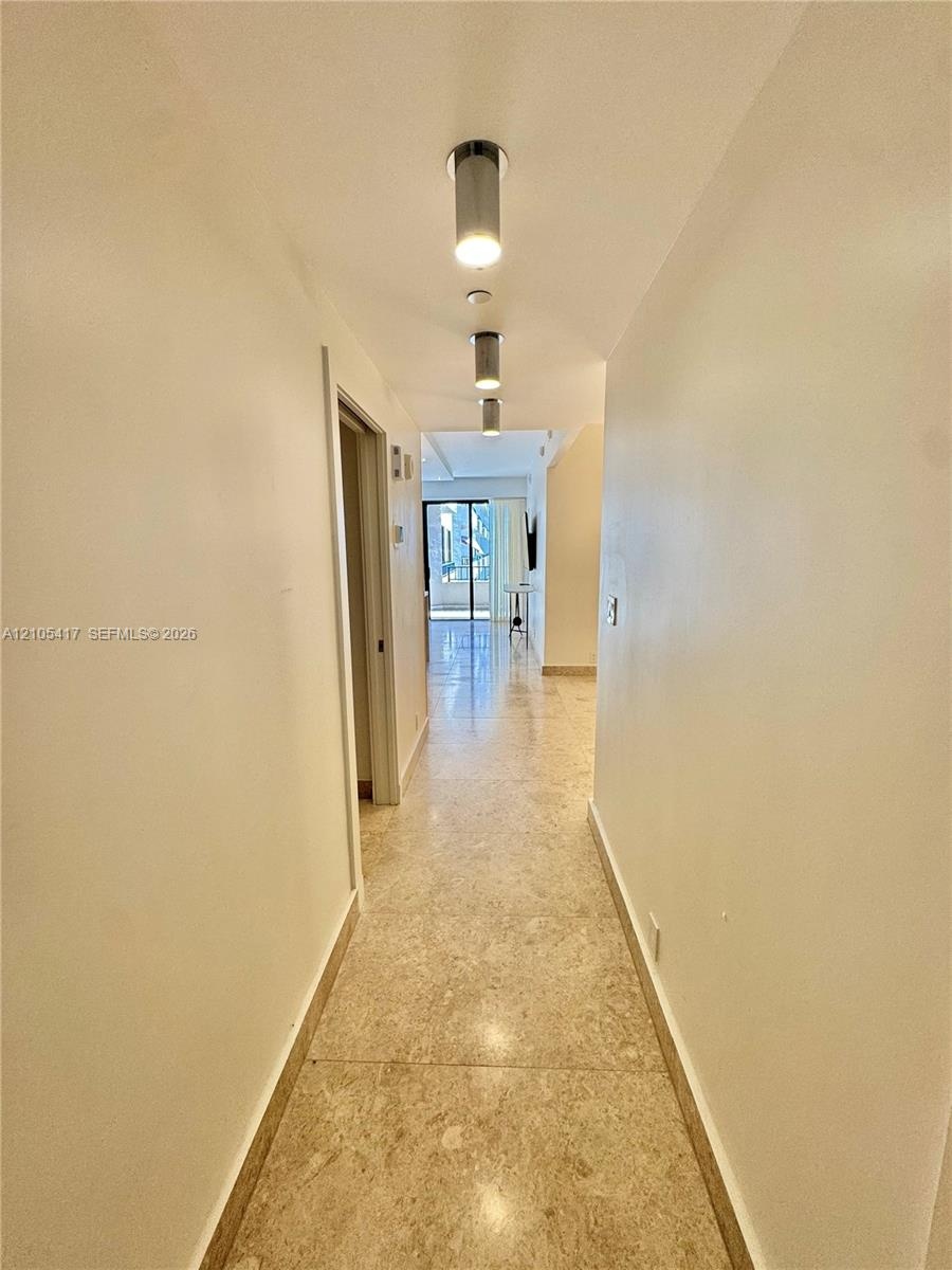 Hallway featuring stone tile flooring and recessed overhead lighting
