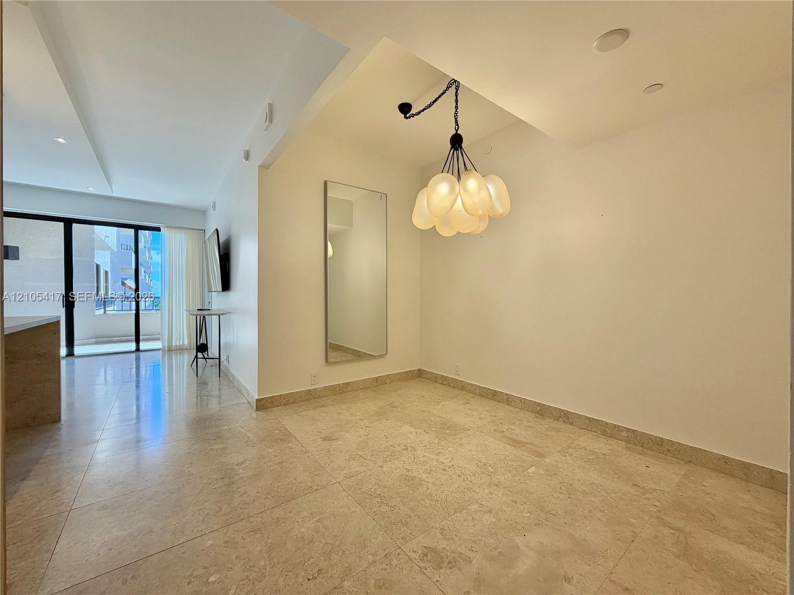 Recessed lighting, contemporary chandelier, full-height mirror, and tile flooring