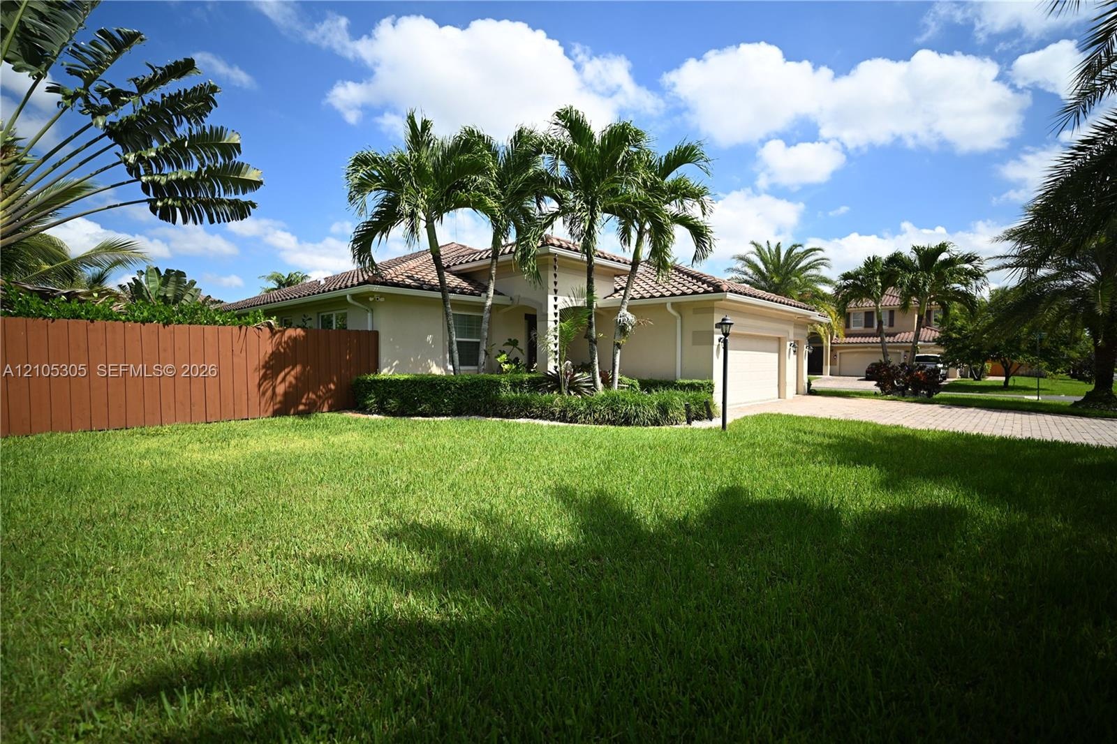 Exterior with a tile roof, light-toned stucco, and an attached two-car garage