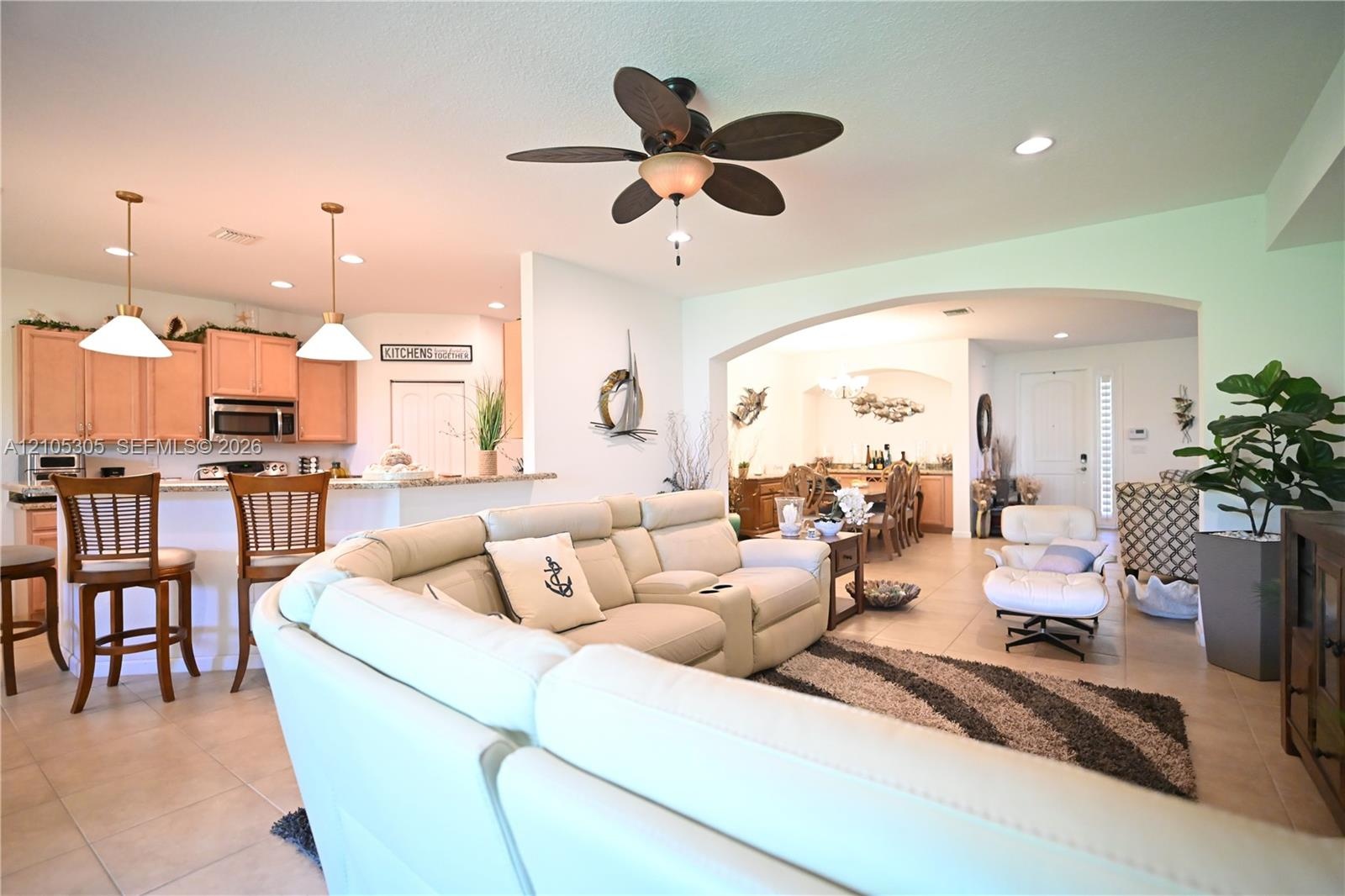 Open-concept living area with tile flooring and recessed lighting