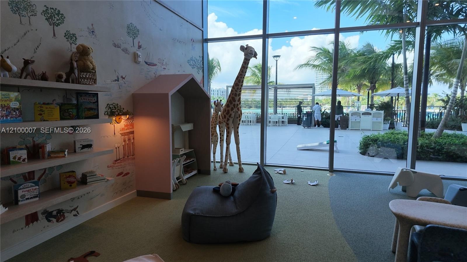 Floor-to-ceiling windows, patterned accent wall, built-in shelving, recessed lighting, and direct exterior access