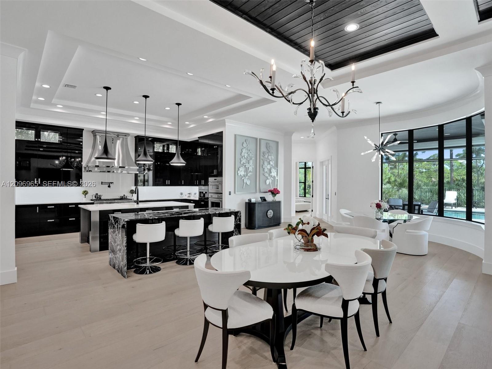 Coffered ceiling with dark-toned plank inlay, recessed lighting, wood-finish flooring, iron chandelier, and high-gloss cabinetry