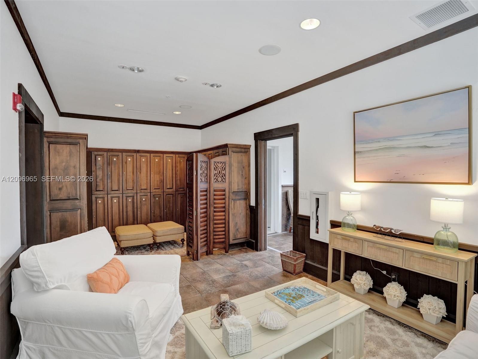 Custom built-in closet organization featuring high-gloss cabinetry, floor-to-ceiling shelving, multiple hanging rods, and integrated recessed lighting