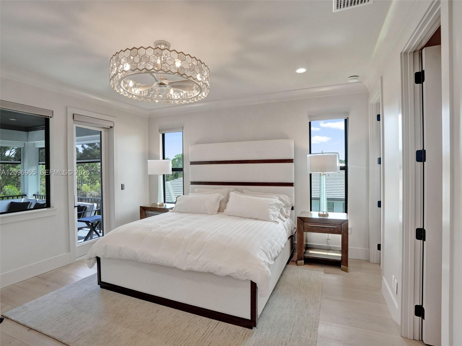 Statement wall featuring book-matched stone cladding with dark border detailing and a contemporary tiered chandelier