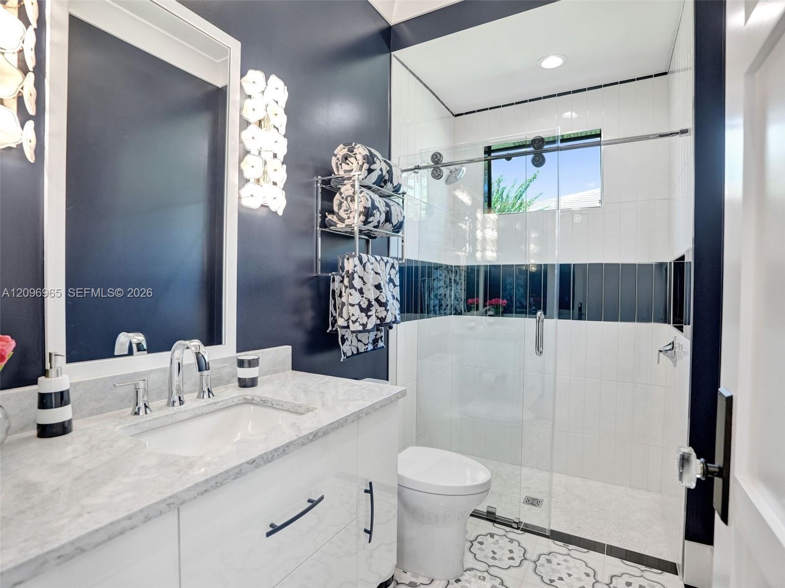 Stainless steel professional-grade range with integrated griddle, wall-mounted matte black pot filler, oversized stainless steel range hood, and solid