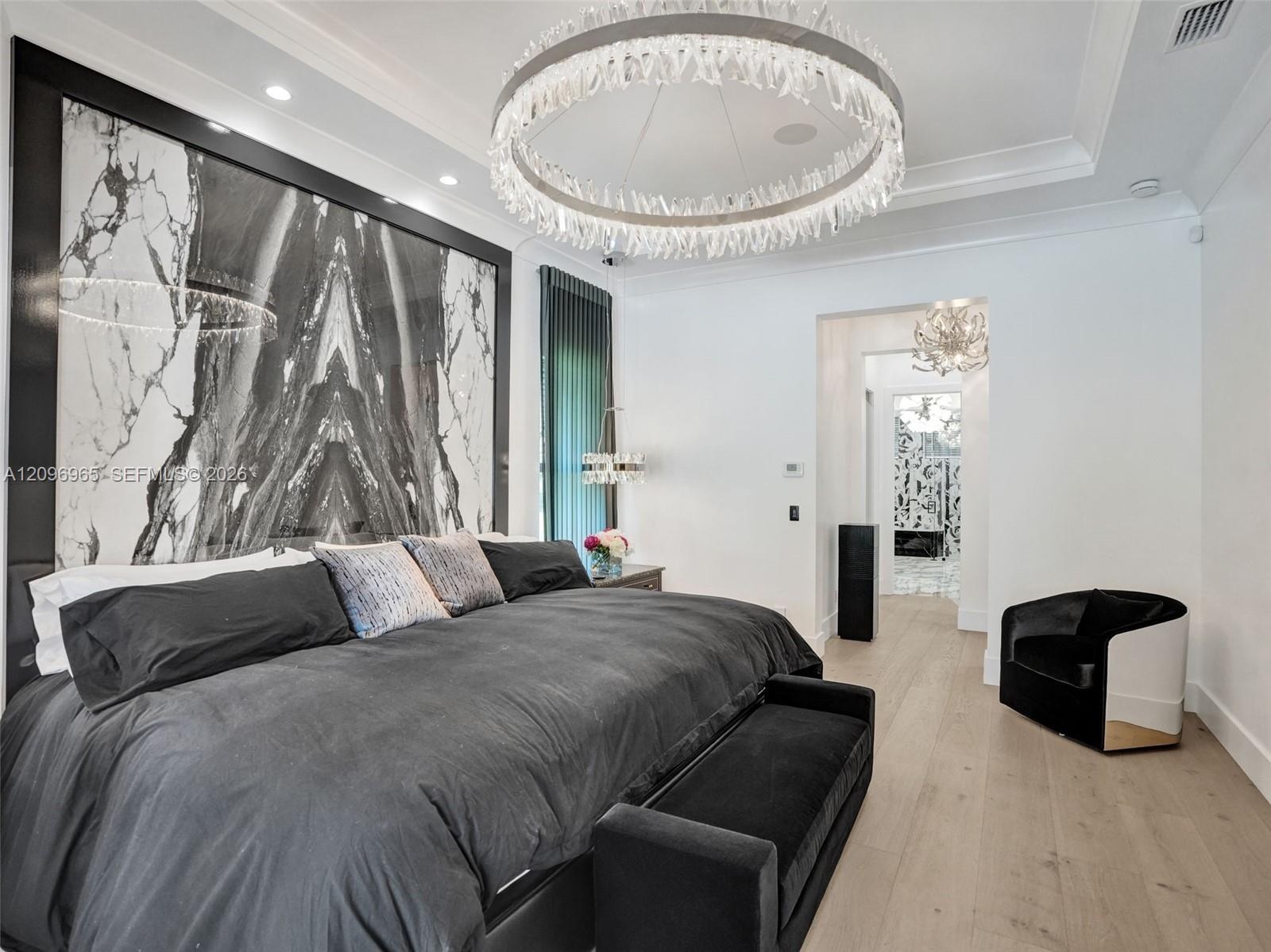 Curved floor-to-ceiling windows with black frames, wood-finish flooring, modern starburst chandelier, and crown molding