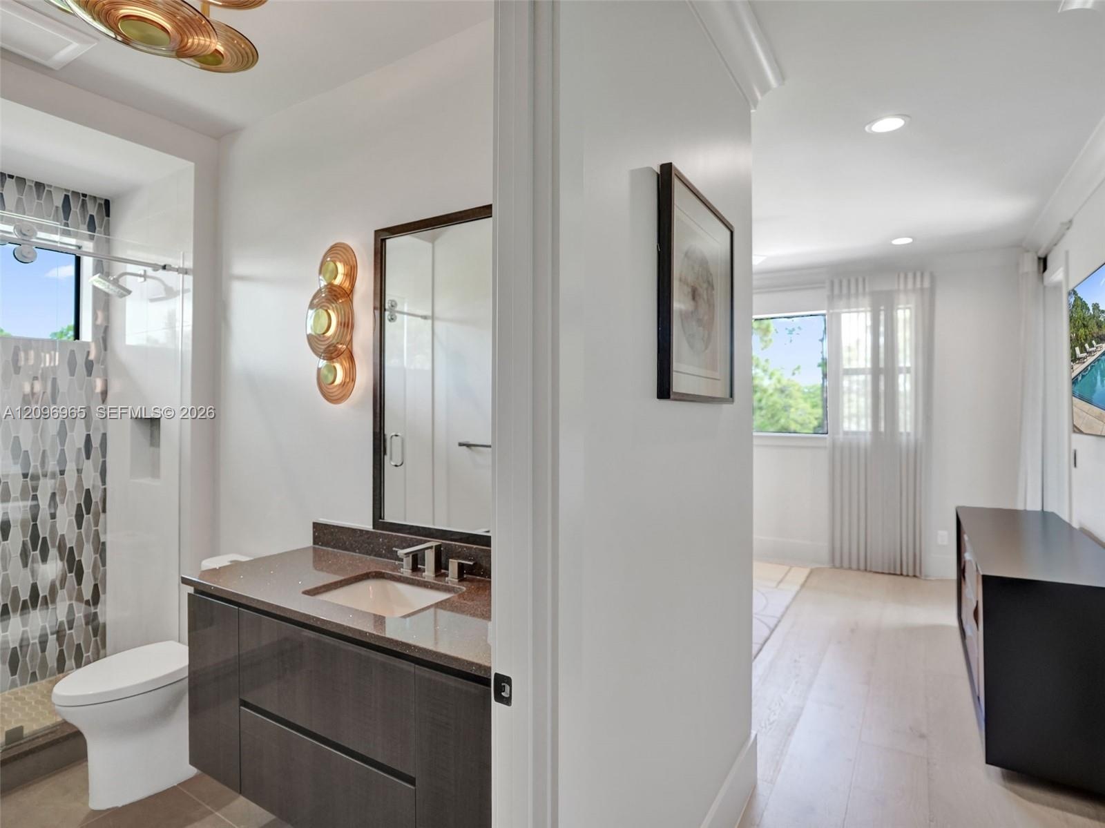 Custom walk-in closet featuring white floor-to-ceiling built-in cabinetry, polished chrome hardware, integrated mirror panels, and a decorative overhe