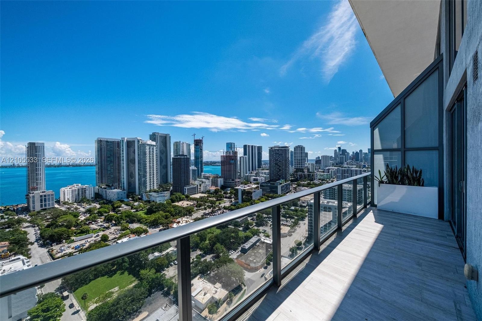 Private balcony featuring tile flooring and a glass panel railing