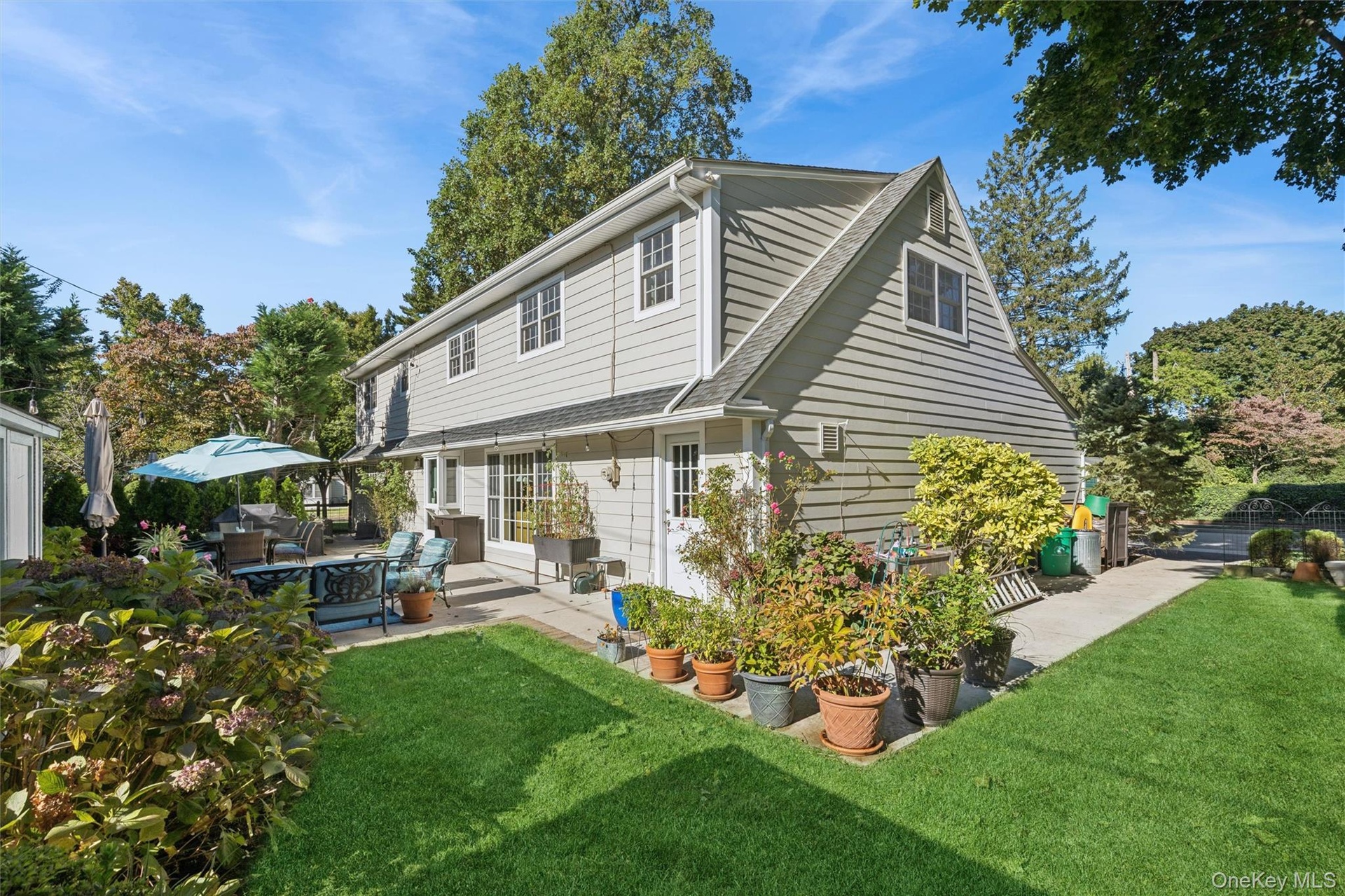 Roses, hydrangeas & mature plantings ensure privacy on this expansive backyard space