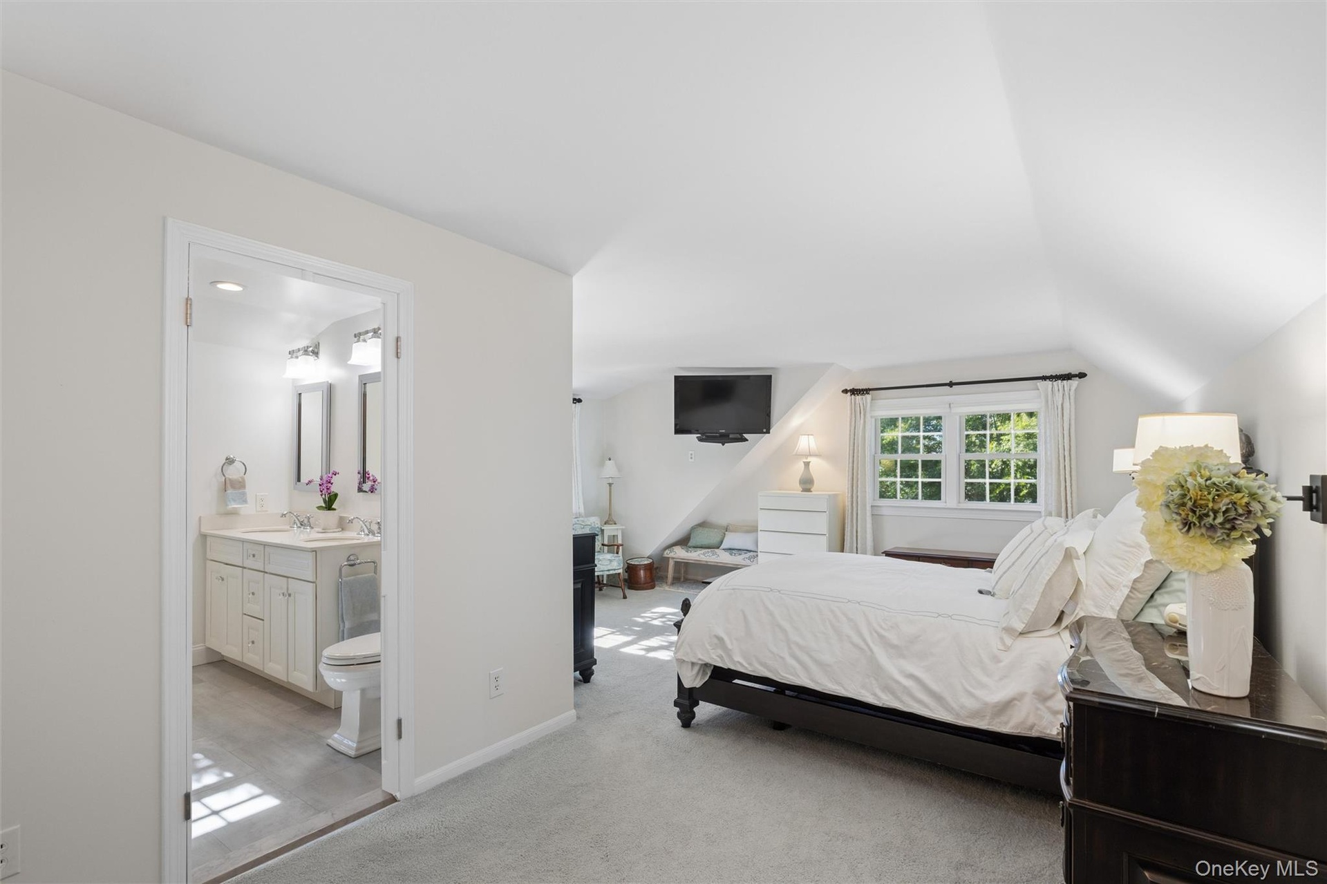 Primary bedroom is spacious and serene offering two WIC and access to the renovated bath