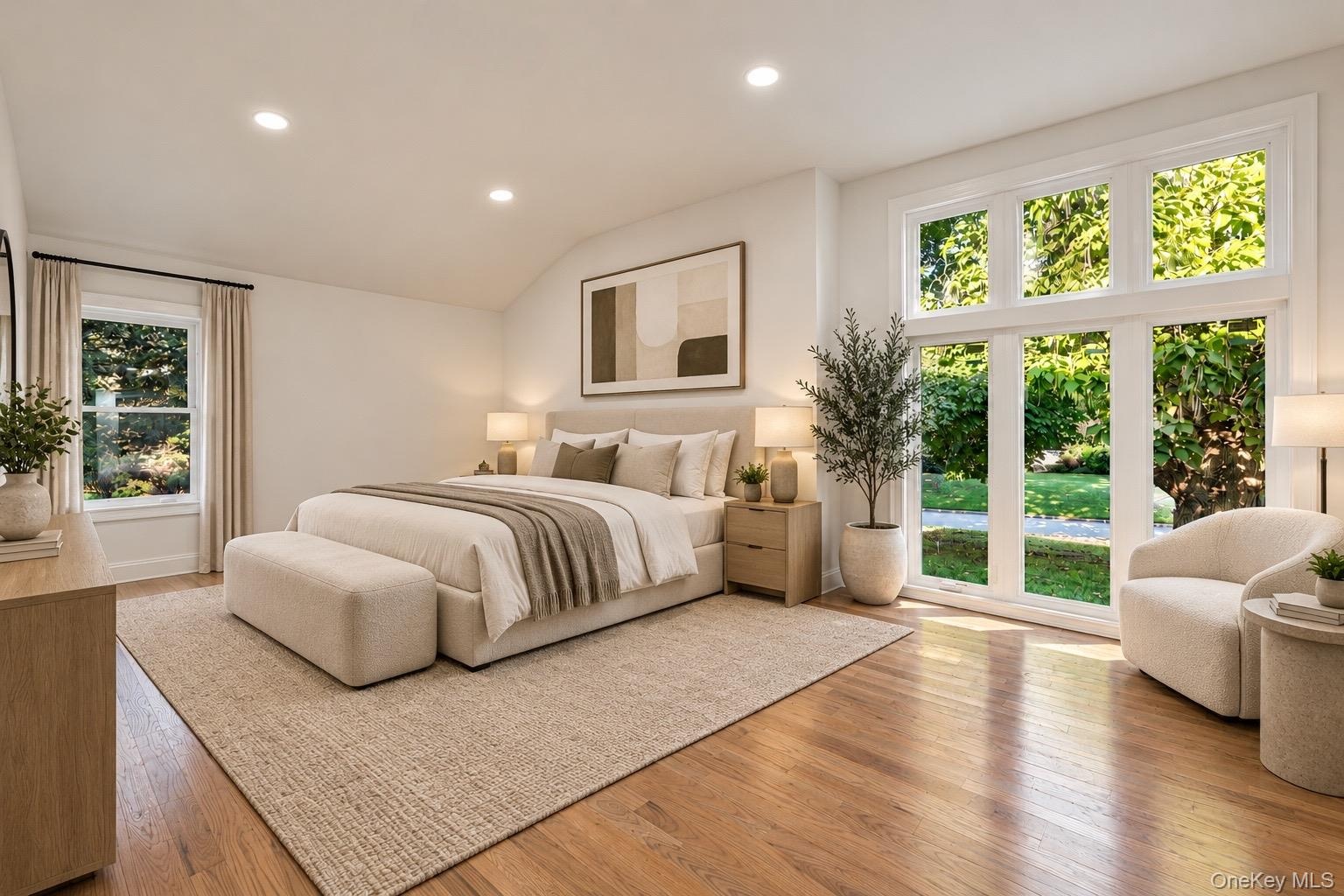 Vaulted ceilings, wood-finish flooring, recessed lighting, and expansive multi-pane windows