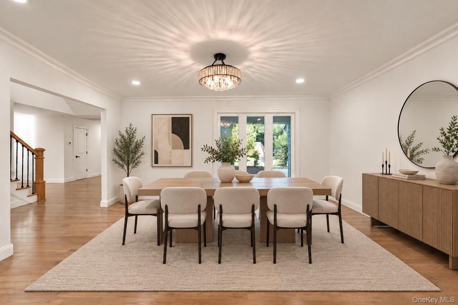 Dining area featuring wood-finish flooring, recessed lighting, crown molding, and a tiered crystal drum chandelier