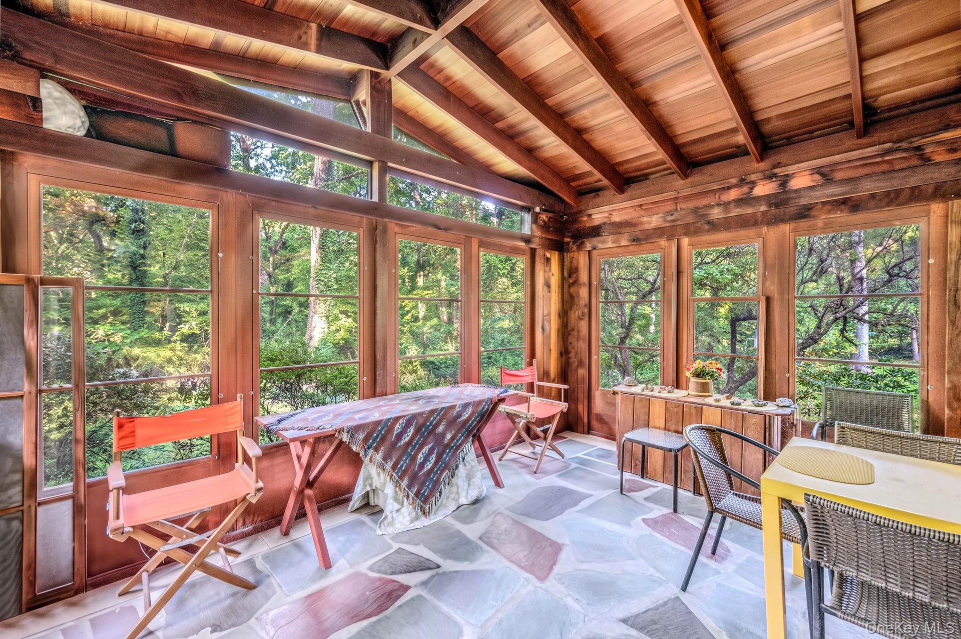 Sunroom with slate floor overlooking the beautiful wooded lot