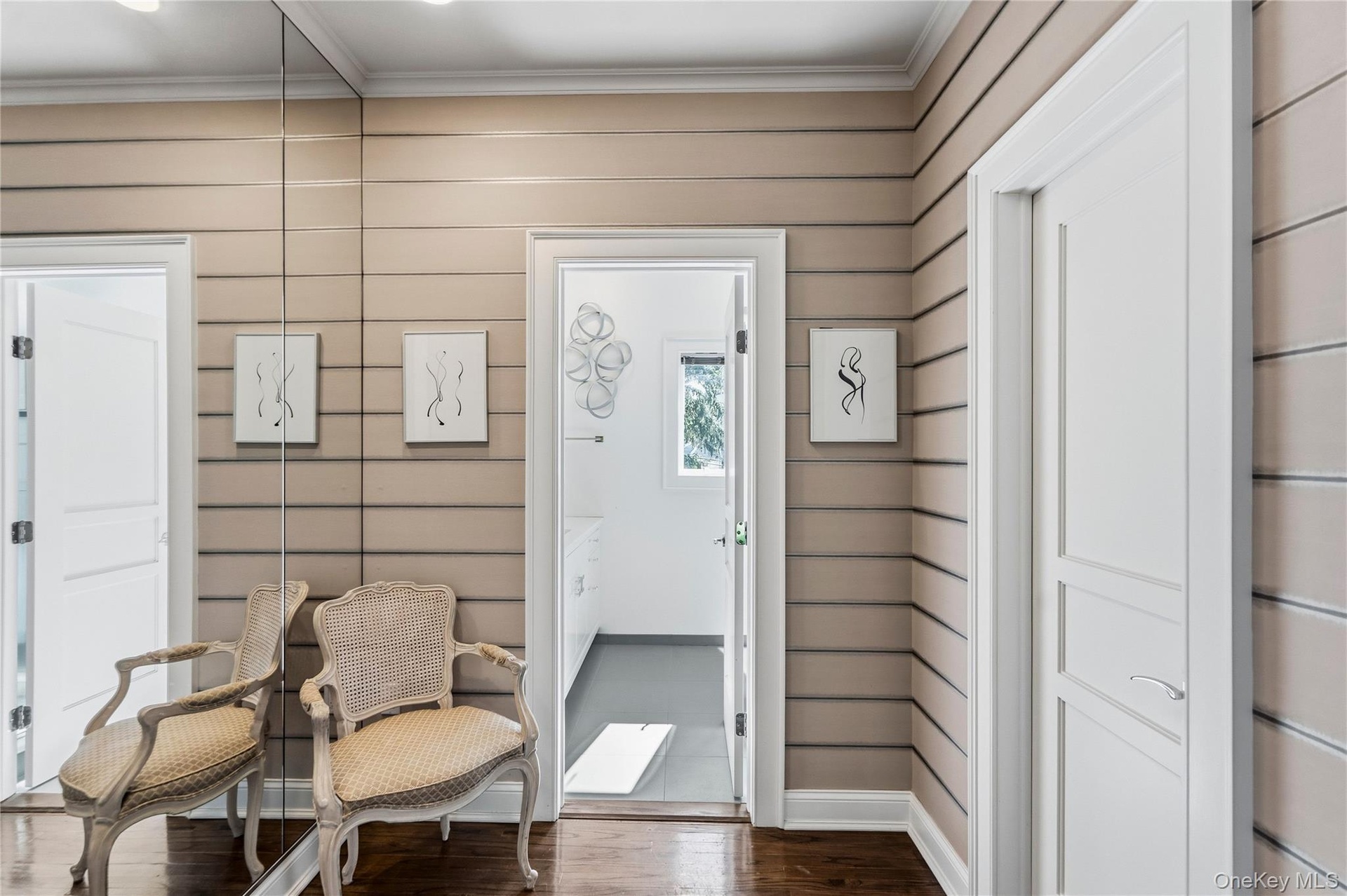 Horizontal plank wall paneling, floor-to-ceiling mirror, and solid-core interior doors with multi-panel detailing