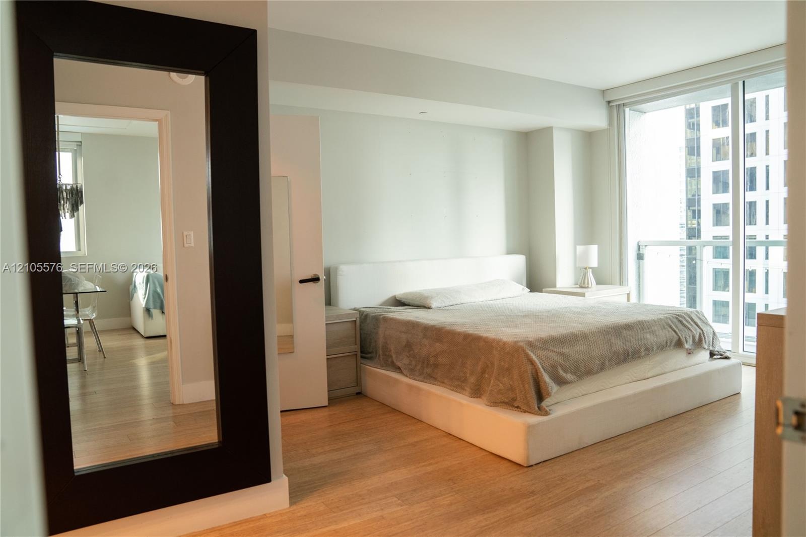 Wood-finish flooring, full-height windows, and neutral interior wall color