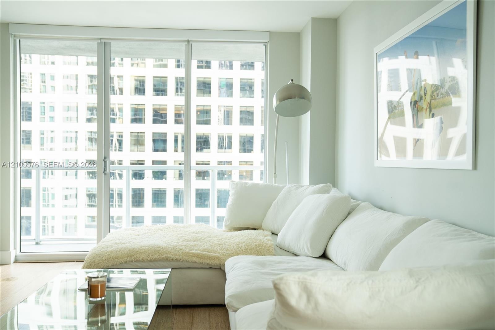 Living room with white sectional sofa and floor-to-ceiling windows