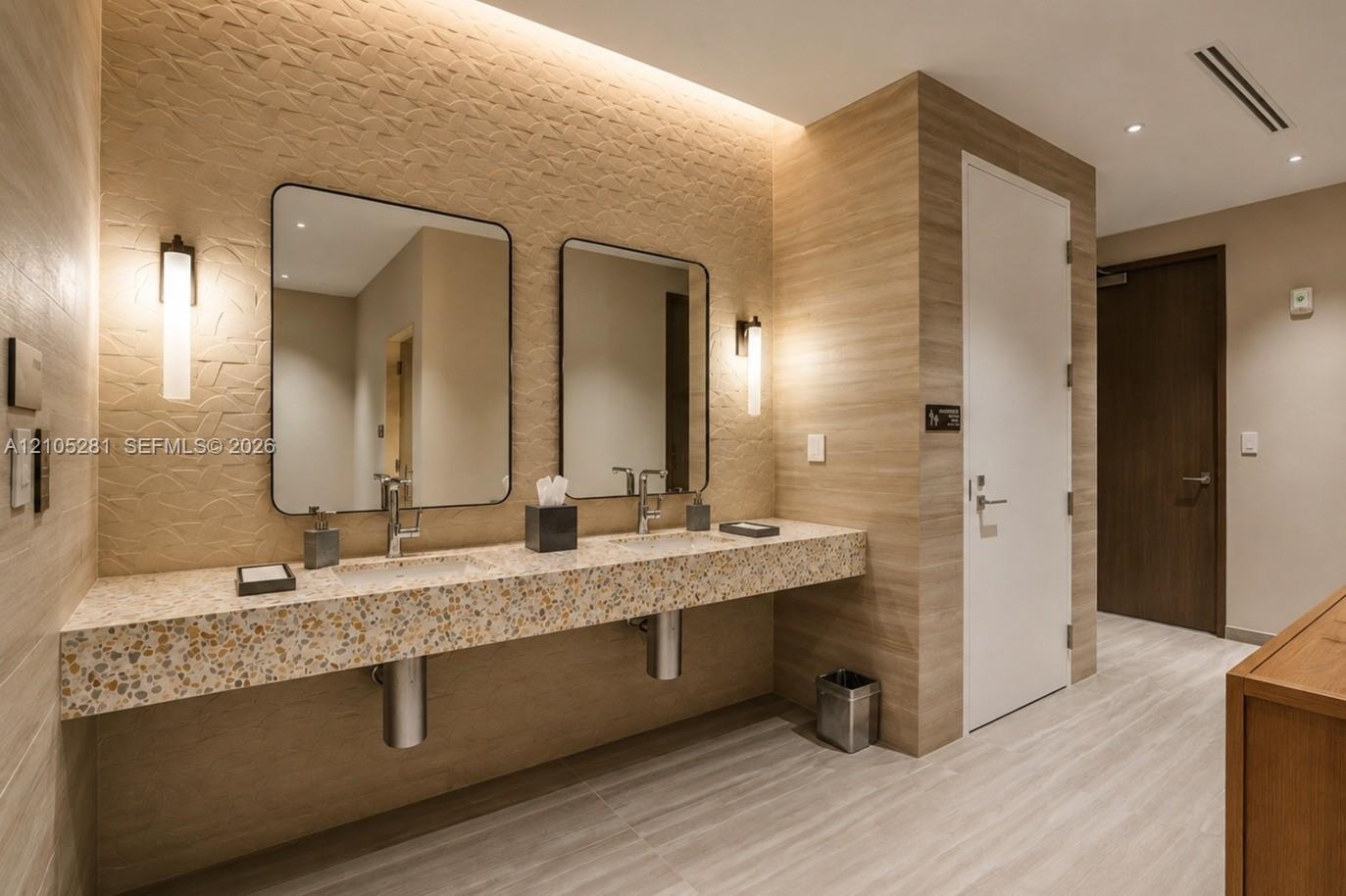 Floating vanity with a speckled countertop, dual rectangular sinks, recessed LED accent lighting, textured wall detailing, and sleek, minimalist wall-