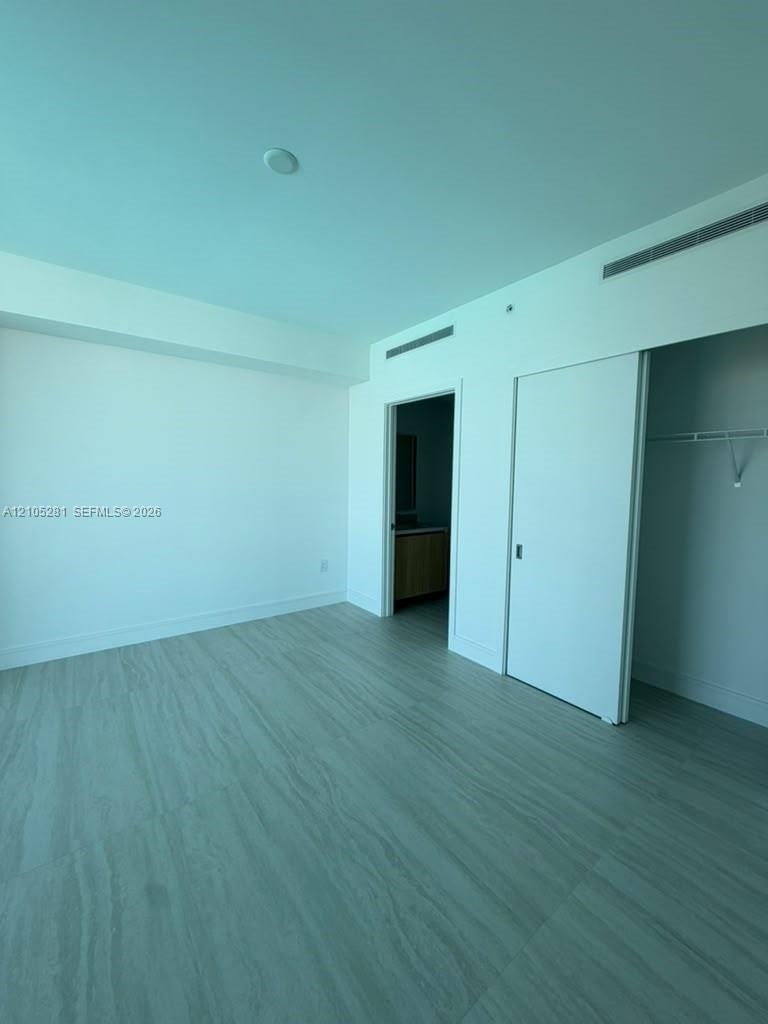Room featuring wood-finish flooring, recessed ceiling lighting, and a sliding closet door