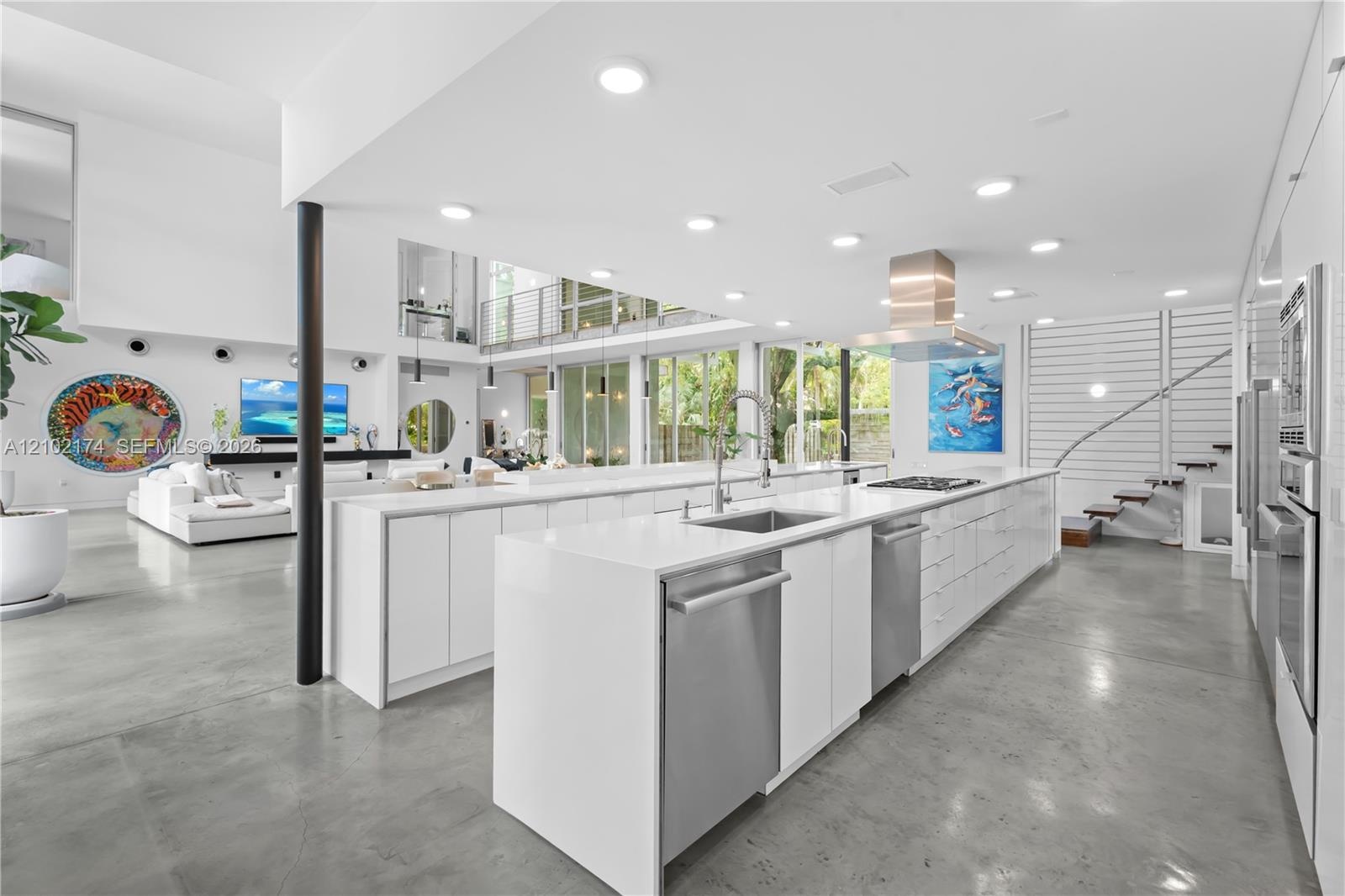 Double-height living area with floor-to-ceiling glass walls, polished concrete flooring, open-concept kitchen with built-in cabinetry, and wood-finish