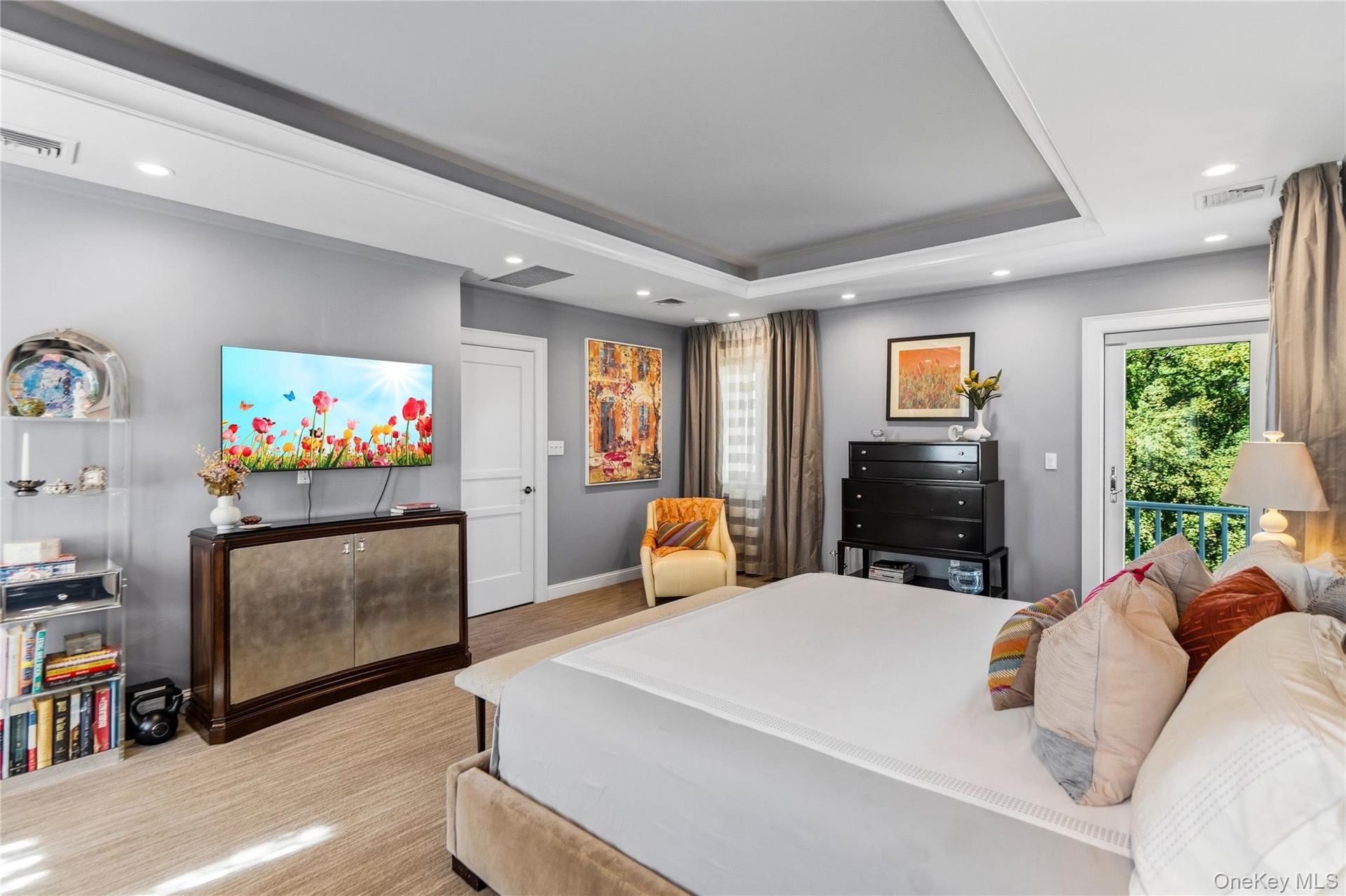 Tray ceiling with recessed lighting, neutral wall color, and glass door access to an exterior balcony