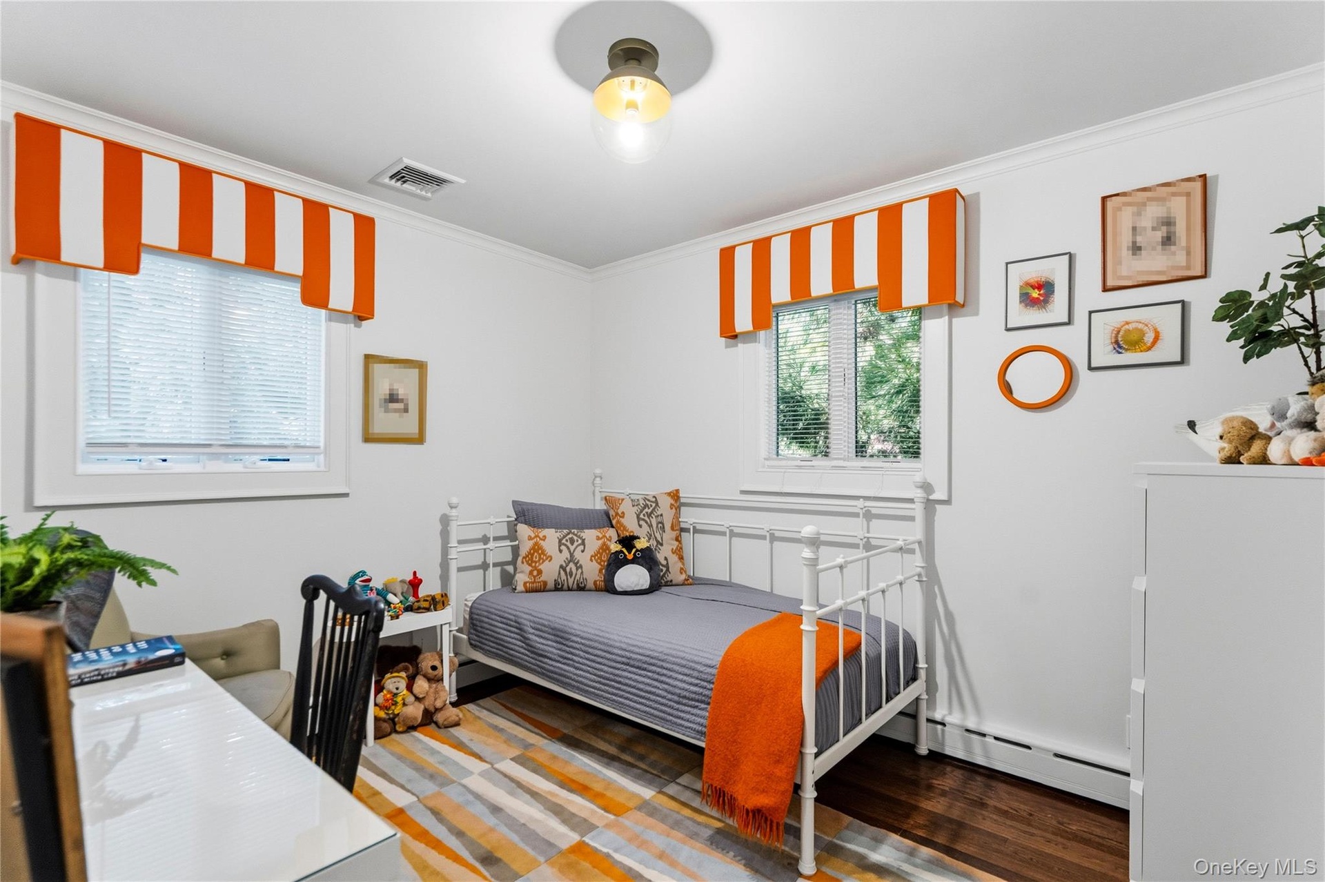 First Floor Bedroom  featuring wood-finish flooring, two dual-pane windows with integrated blinds, and a central glass globe light fixture