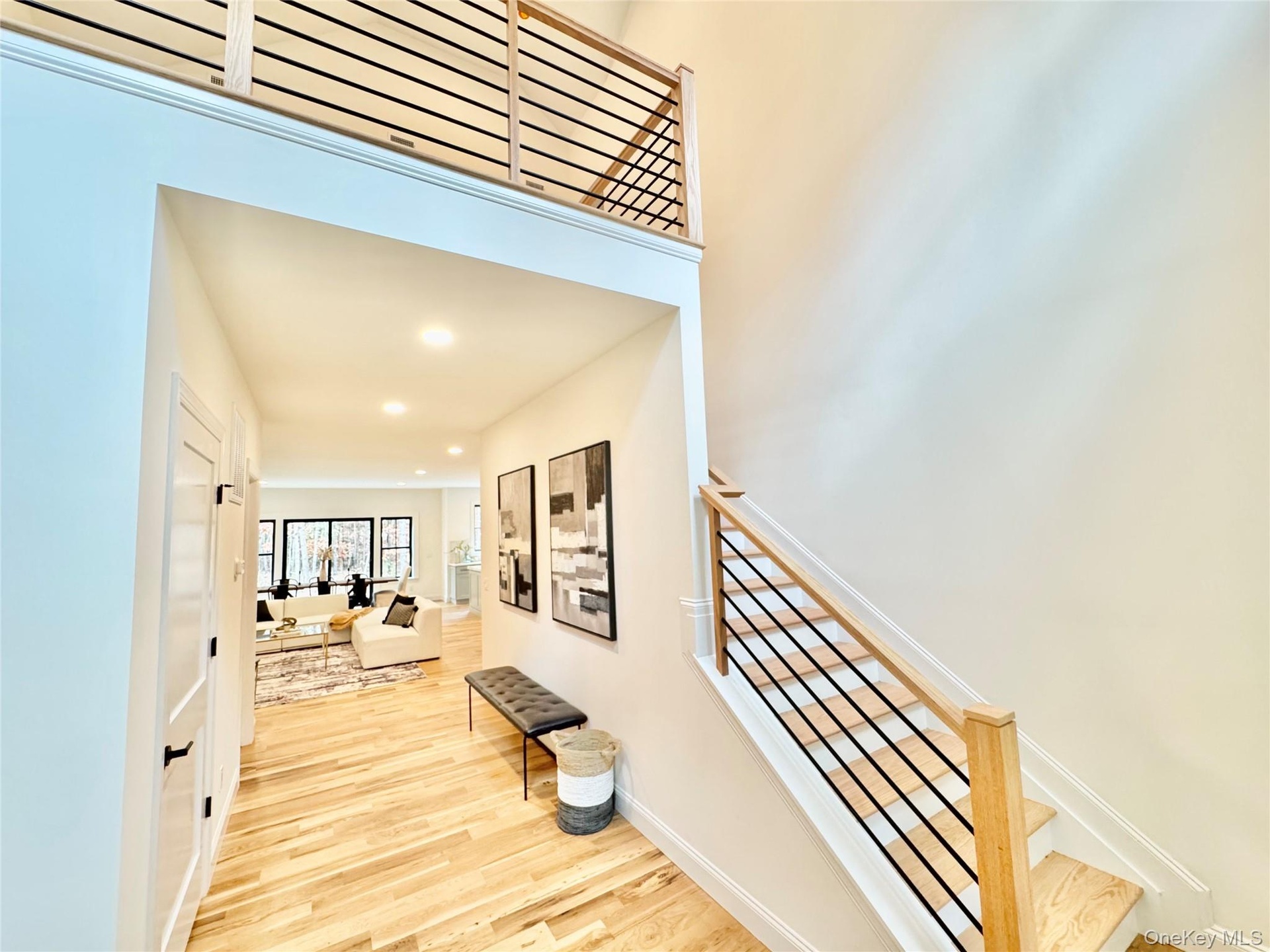 Hall with light wood finished floors and recessed lighting
