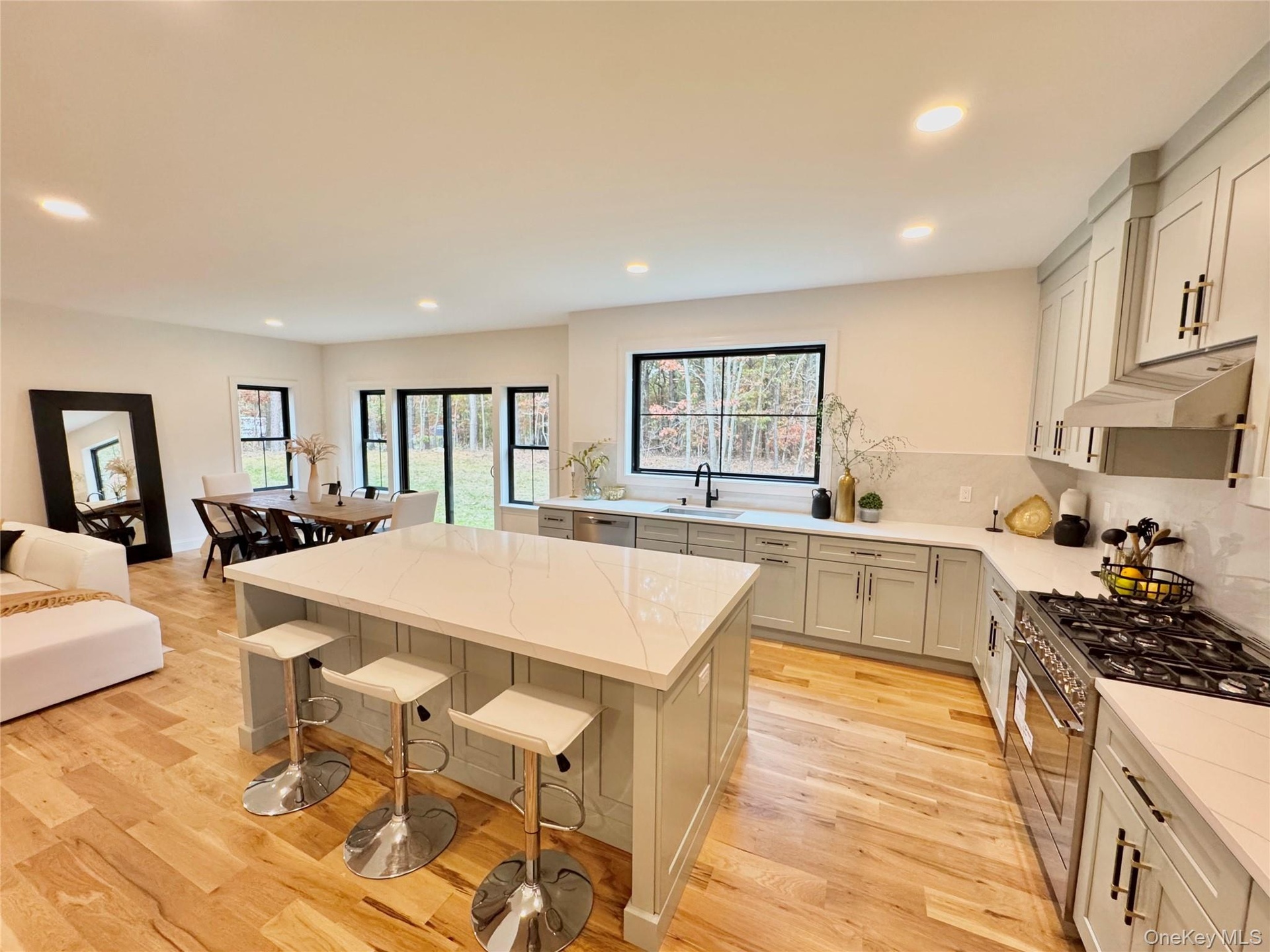 Kitchen with stainless steel appliances, decorative backsplash, recessed lighting, a center island, and light wood-style floors