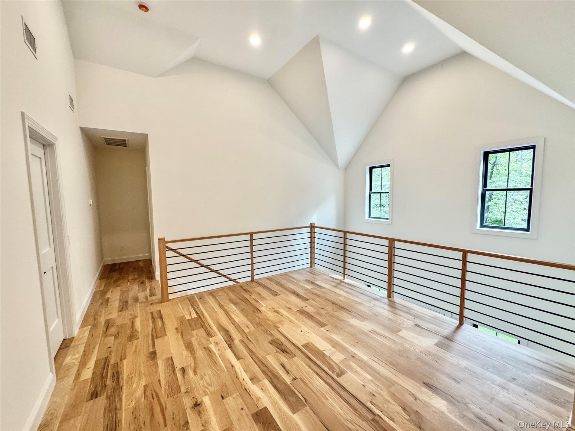 Additional living space featuring light wood-style floors, recessed lighting, and high vaulted ceiling